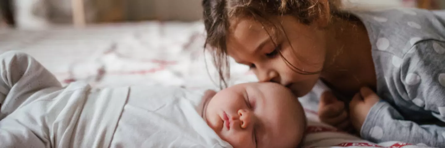 Große Schwester küsst Baby