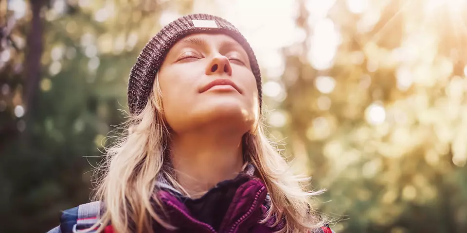 Frau genießt die Sonne im Wald