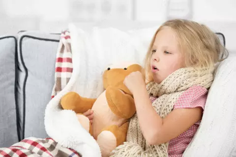 Mädchen liegt mit Bronchitis im Bett