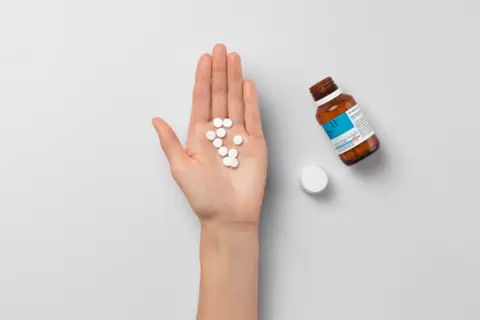 Hand hält Schüßler-Salze Tabletten