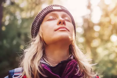 Frau genießt die Sonne im Wald