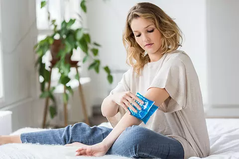 Frau kühlt sich den Arm
