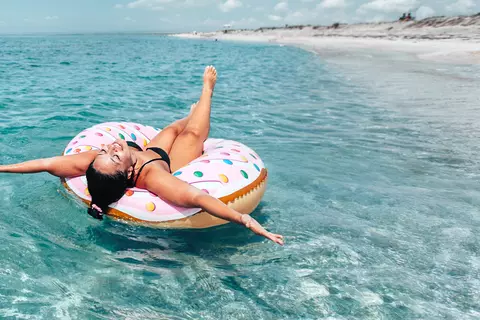 Frau mit Luftmatratze im Meer