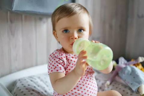 Baby trinkt aus einem Becher
