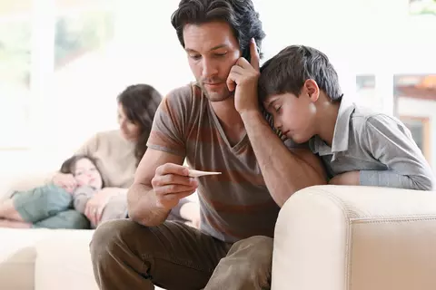 Vater misst Fieber bei seinem Sohn