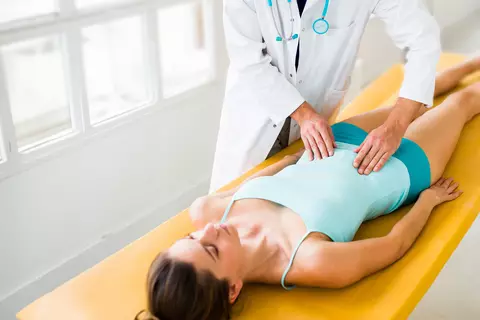 Arzt tastet Bauch bei Patientin ab