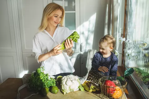 Mutter und Kind mit frischem Gemüse in der Küche