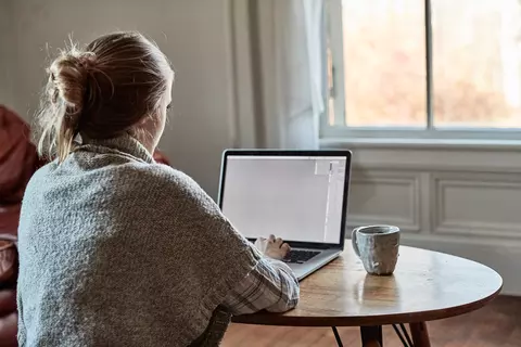 Frau sitzt im Home Office in der Nähe des Fensters