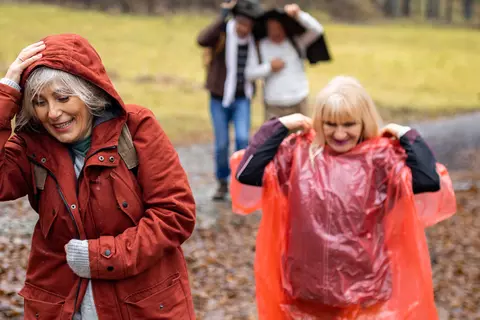 Ältere Menschen versuchen im Regen nicht nass zu werden