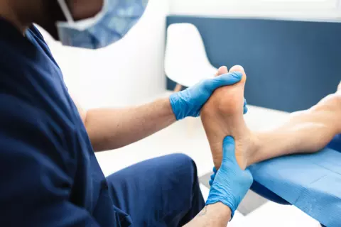 Arzt untersucht den Fuß eines Patienten