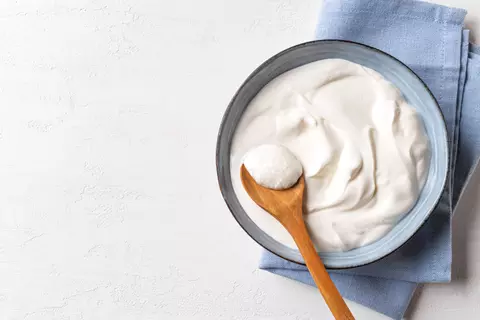 Quark in einer Schüssel mit einem Holzlöffel