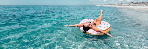 Frau mit Luftmatratze im Meer