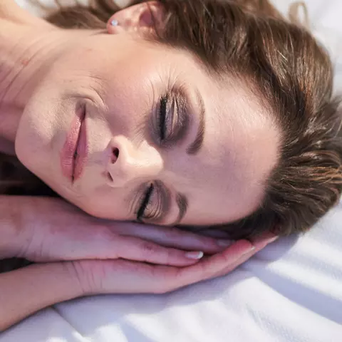 Frau liegt im Bett und schläft