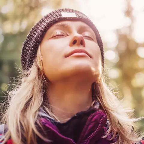 Frau genießt die Sonne im Wald
