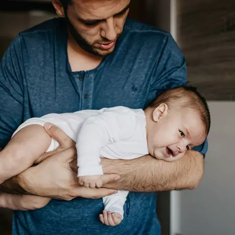 Vater hält einen Säugling auf dem Arm