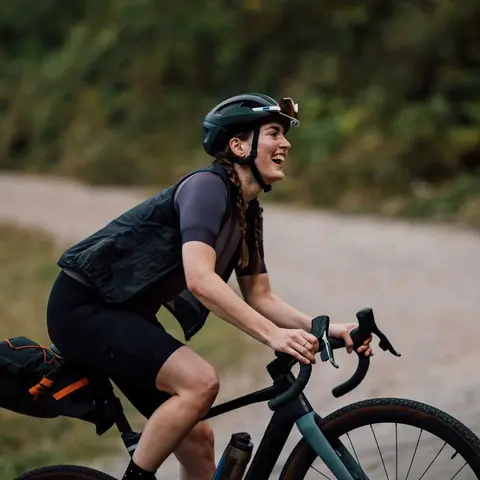 Junge Frau fährt lachend Fahrrad