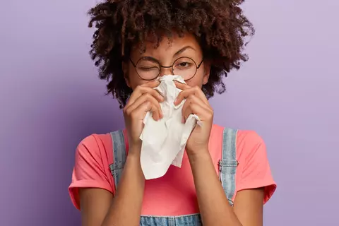 Frau niest wegen Allergie