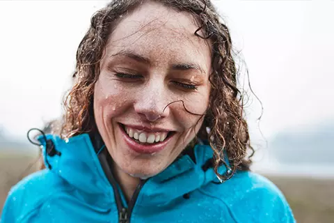 Frau im Regen lacht