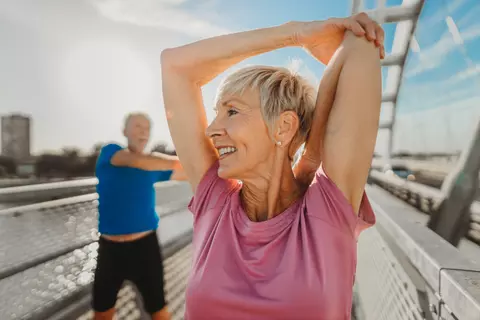Senior und Seniorin machen draußen Sport