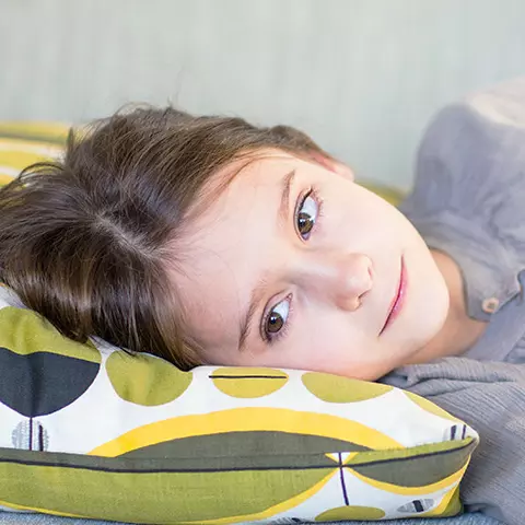 Kind liegt mit Bauchschmerzen auf der Seite