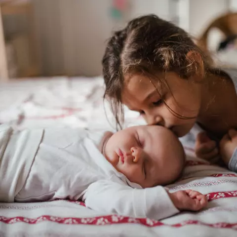 Große Schwester küsst Baby